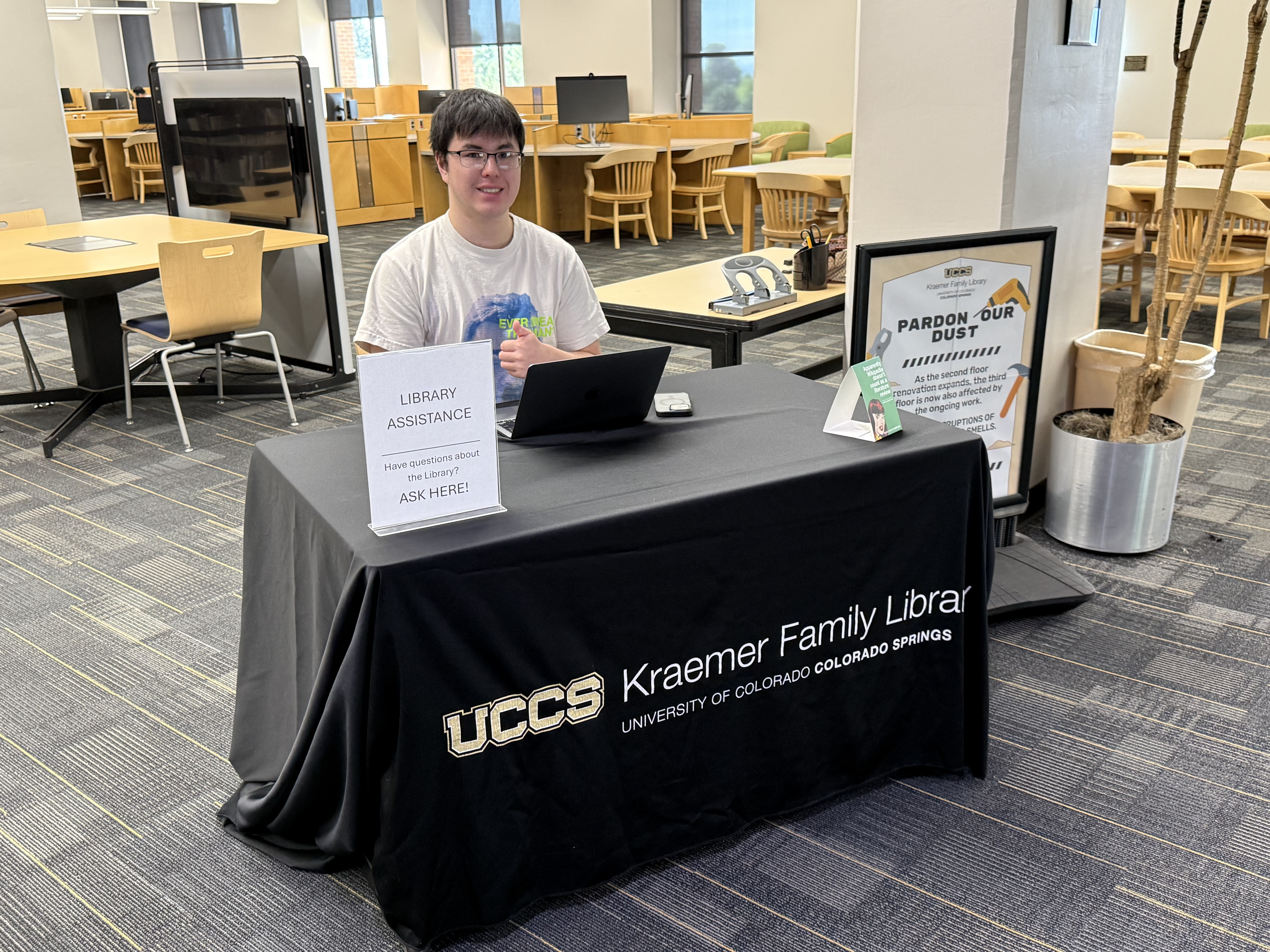 Student stationed at a library greeter station