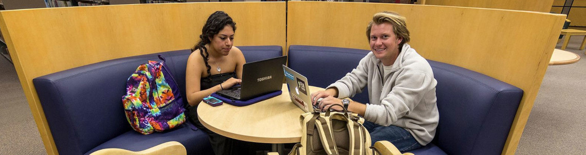 students sitting at a table in the library