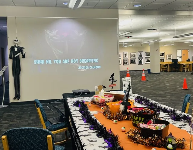projector displaying six-word scary stories on a wall in the library